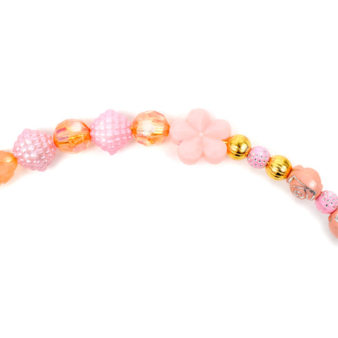 ピンク色のカチューシャの拡大写真です。花型のビーズをメインに、バラの形をしたビーズや金色の丸い形をしたビーズを組み合わせてカチューシャを作ります。