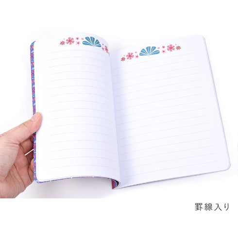 ノートには、罫線と上部に草花が描かれています。