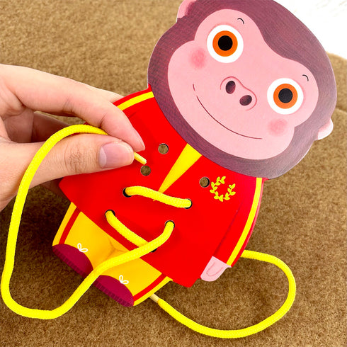 サルの台座で紐通しをしています。黄色い紐が付属しています。