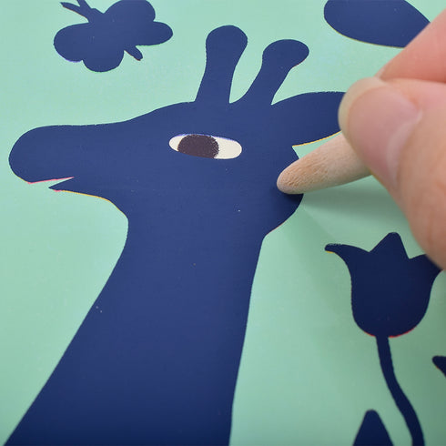 キリンのスクラッチアートを作っています。付属の棒で表面を書くように削っていきましょう。