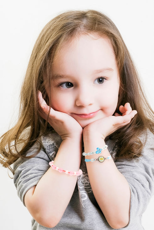 女の子がこの商品を使って作ったブレスレットを身に着けています。アクセサリーを身に着けておしゃれをしましょう。
